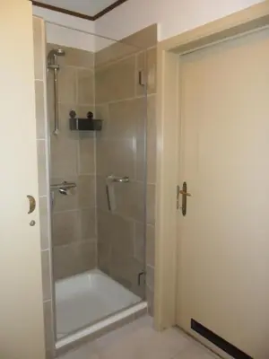 a shower in a bathroom with a glass door at Schophemmerhoeve in Voeren