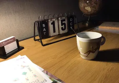 a coffee cup sitting on a table next to a clock at Vakantiewoning - ‘t Ouwershuys in Opoeteren