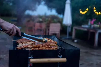 a person is cooking food on a grill at Vakantiewoningen Pomona in Heers