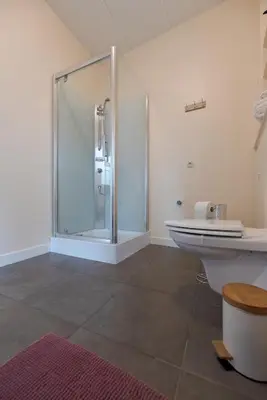 a bathroom with a glass shower and a sink at Vakantiewoningen Pomona in Heers