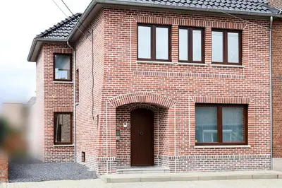 a red brick house with a brown door at BnB Pastel -B&B Breakfast Included- in Dilsen-Stokkem
