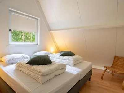 two beds in a room with a window at Boshuisje Rekem - Boris in Lanaken