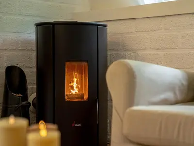 a black heater next to a couch and a chair at Boshuisje Rekem - Boris in Lanaken