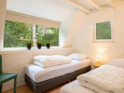 two beds in a room with two windows at Boshuisje Rekem - Boris in Lanaken