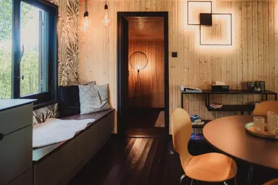 a living room with a couch and a table and a window at Ô NaNo Glamping in Dalhem