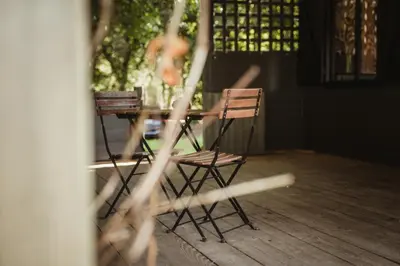 two chairs sitting at a table on a porch at Ô NaNo Glamping in Dalhem