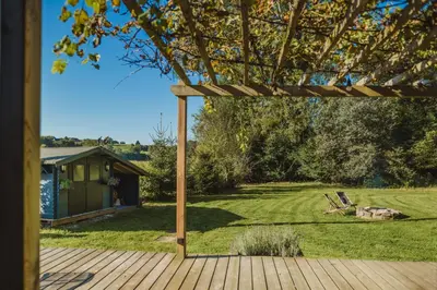 a wooden deck with a view of a yard at Ô NaNo Glamping in Dalhem