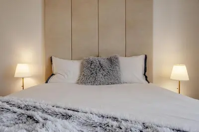 a bed with white sheets and pillows with two lamps at Marshmallow in Liège