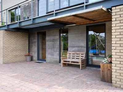 a wooden bench sitting on a patio under a balcony at La tanière in Chaudfontaine