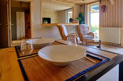 a wooden table with two bowls and glasses on it at La tanière in Chaudfontaine