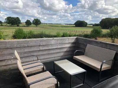 two chairs and a table and two chairs on a porch at Welness gastenverblijf Carpe Diem in Oudsbergen