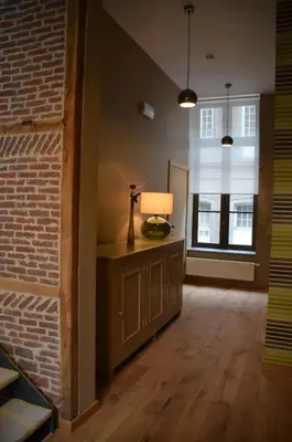 a living room with a lamp and a brick wall at B&B N°5 in Liège