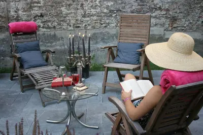 a woman sitting in a chair reading a book at B&B N°5 in Liège