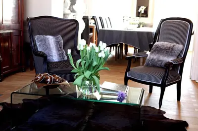 a living room with two chairs and a glass table with flowers at B&B N°5 in Liège