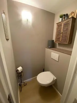 a small bathroom with a toilet and a light at bij Petros in Oudsbergen