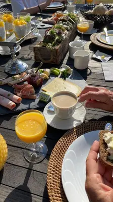 a table with plates of food and drinks on it at Bed & Bokes aan de Maaskant in Lanaken