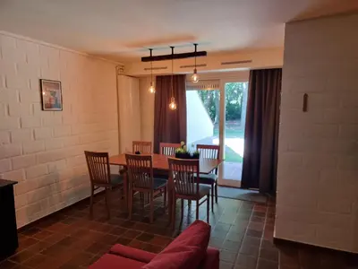 a dining room with a table and chairs at Gezellig appartement in groene omgeving in Drijhoeven