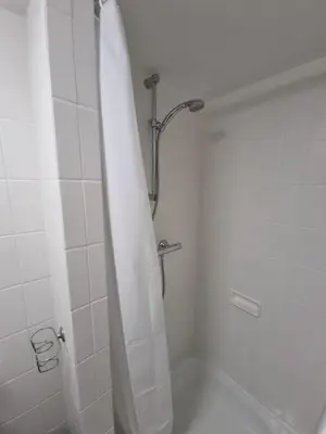 a bathroom with a shower with a shower curtain at Gezellig appartement in groene omgeving in Drijhoeven