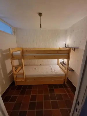 a bunk bed in a room with a brick wall at Gezellig appartement in groene omgeving in Drijhoeven