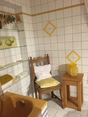 a bathroom with a chair and a sink and a mirror at Haus Dany in Raeren