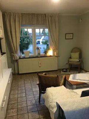 a bedroom with a bed and a window and a table at Haus Dany in Raeren
