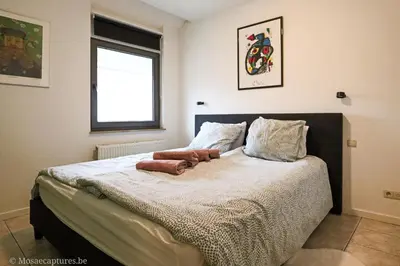 a bedroom with a large bed with a window at De Millenniumhoeve (Willy) in Riemst