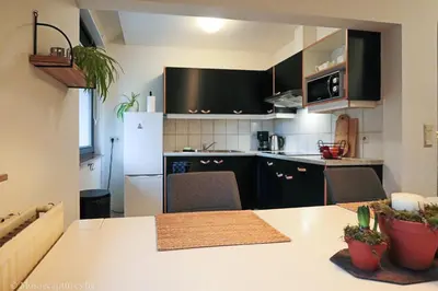 a kitchen with black cabinets and a white refrigerator at De Millenniumhoeve (Willy) in Riemst