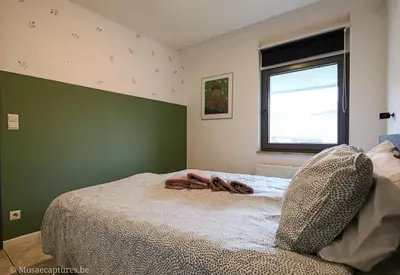 a bedroom with a bed with a green wall at De Millenniumhoeve (Willy) in Riemst