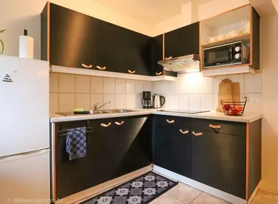 a kitchen with black cabinets and a white refrigerator at De Millenniumhoeve (Willy) in Riemst