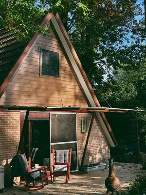 a house with two chairs in front of it at Mimi's natuurhuisje in Lanaken