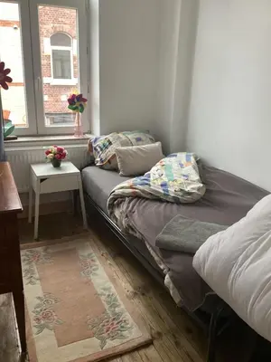 a room with a couch and a table and a window at Les chineurs du 81 in Liège