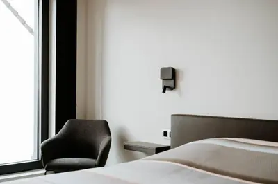 a bedroom with a bed and a chair next to a window at B&B Koor91 in Hasselt