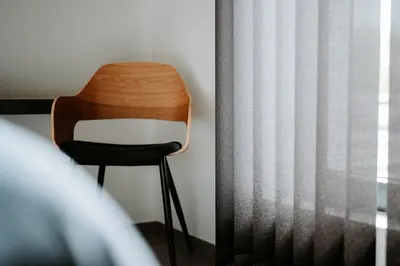 a wooden chair sitting next to a window at B&B Koor91 in Hasselt