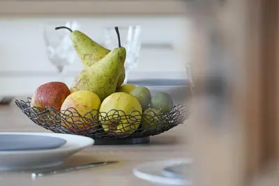 a bowl of pears and other fruits on a table at Gîtes Chez Oncle Nicolas in Soumagne