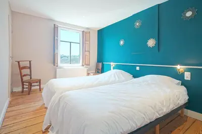 a bedroom with two beds and a blue wall at Gîtes Chez Oncle Nicolas in Soumagne