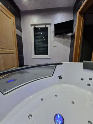 a white bath tub in a bathroom with a tv at Tendresse - Espace Détente Ensival in Verviers