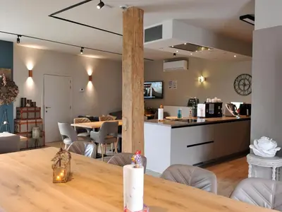a dining room and kitchen with a table and chairs at Vlaanderen Cozy Cottage in Eisden