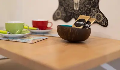 a wooden table with a bowl with cups on it at La Chambre Suspendue by Maison Brasseurs d'Etoiles - Appartement 2 personnes in Liège