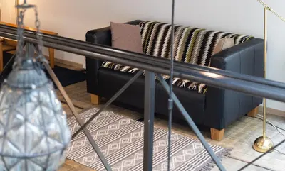 a black couch in a living room with blankets at Le Loft Nautilus by Maison Brasseurs d'Etoiles in Liège