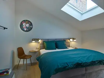 a bedroom with a bed and a skylight at lit-loo in Hasselt