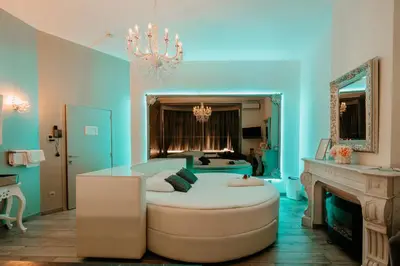 a blue room with a large bed and a chandelier at Ô Secret in Liège