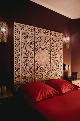a bedroom with a red bed with a large headboard at Ô Secret in Liège