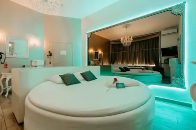 a bedroom with a large white bed with a mirror at Ô Secret in Liège