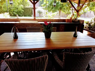 a wooden table with a vase of flowers on it at JustB in Riemst