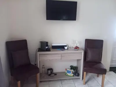 two chairs sitting next to a desk with a television on the wall at JustB in Riemst