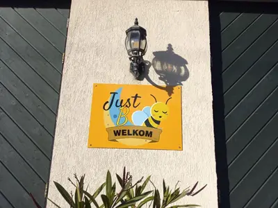 a sign on the side of a wall with a light at JustB in Riemst