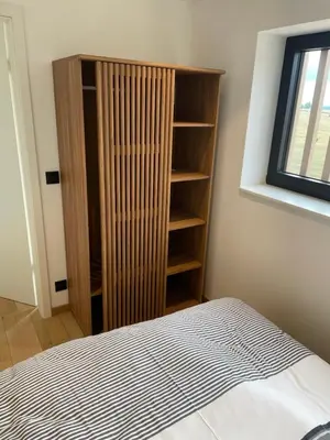 a bedroom with a book shelf and a bed at Tiny house moderne in Thimister