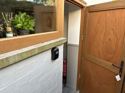 a door with a sensor on it next to a window at Route 123 Birchwood Pension in Kortessem