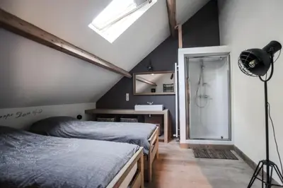 a attic bedroom with two beds and a shower at Villa Vigor in Peer