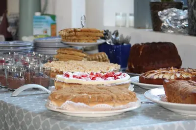 a table topped with cakes and other desserts on plates at Villa Vigor in Peer